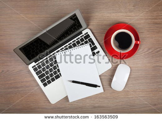 stock-photo-blank-notepad-over-laptop-and-coffee-cup-on-office-wooden-table-163563509