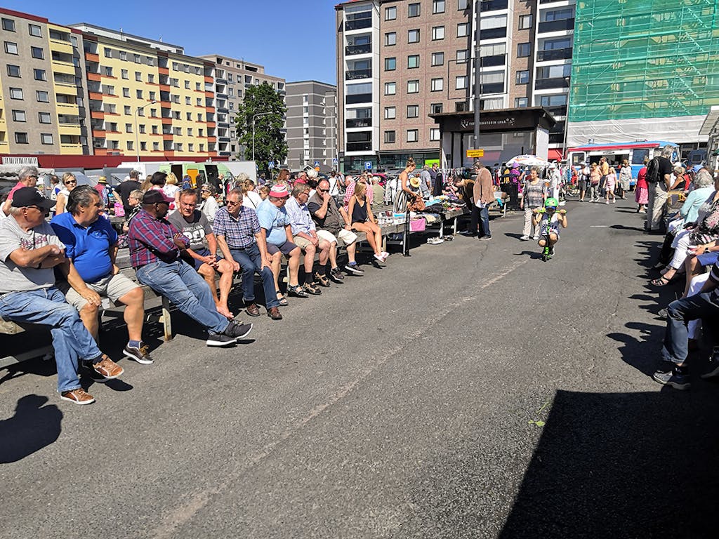 Ihmiset istuvat aurinkoisella torilla Tampereella.