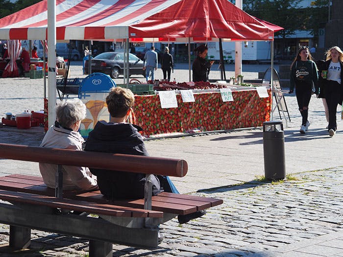 People sitting on a bench in the marketplace in Vaasa.