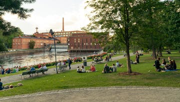 Ihmisiä nauttimassa kesäillasta Tampereen Koskipuistossa
