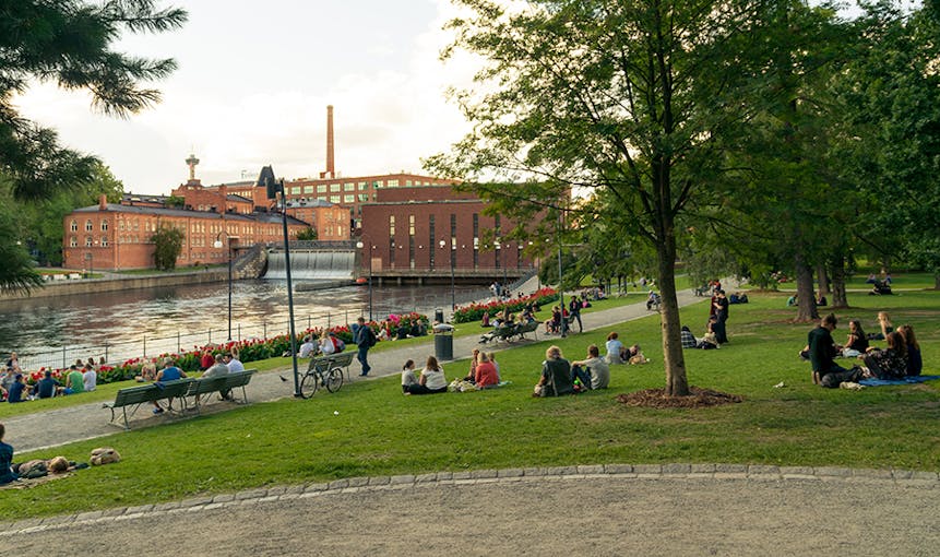 Ihmisiä nauttimassa kesäillasta Tampereen Koskipuistossa
